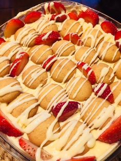 a dessert dish with strawberries and cream drizzled on the top is ready to be eaten