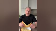 an older man is eating some bread on a plate