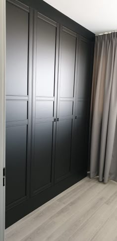 an empty room with black closets and curtains