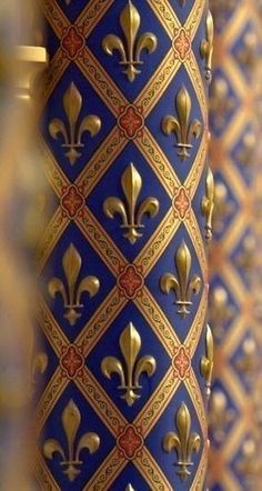 a blue and gold vase with fleur de lis on it's side