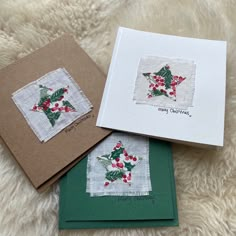 three christmas cards with holly designs on them