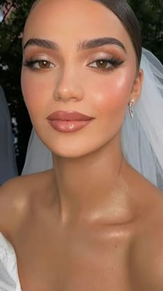 a woman in a wedding dress with makeup on her face and veil over her head