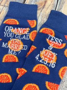 two blue socks with oranges on them that say, orange you glad to married me?