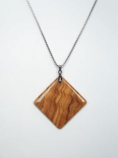 a necklace with a wooden pendant hanging from it's side