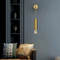 a living room filled with furniture and a gold light hanging from the ceiling above it