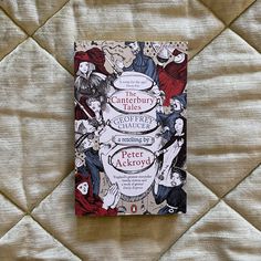 a book sitting on top of a bed next to a quilted wallpaper covered in white and red