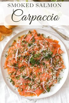 smoked salmon carpaccioa with parmesan cheese and herbs on a white plate