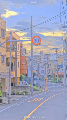 an orange and white street sign sitting on the side of a road next to tall buildings