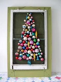 a christmas tree made out of ornaments in a window