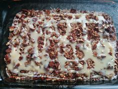 a casserole dish is covered with pecans and icing in a glass pan