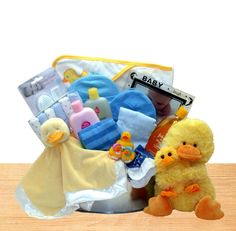 a baby gift basket with a ducky toy and diaper on the floor next to it