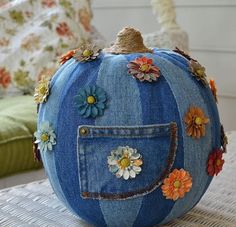 a denim pumpkin with flowers on it sitting on a table