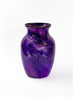 a purple vase sitting on top of a white table