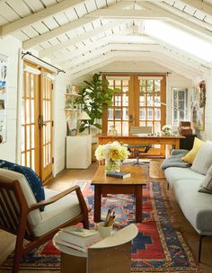 a living room filled with lots of furniture and decor on top of a wooden floor