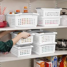 a woman is picking up some food from the shelves