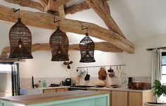 a kitchen with wooden beams and hanging birdcages