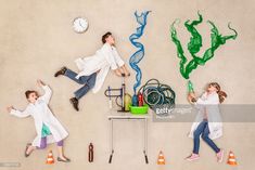 three people in white lab coats are laying on the ground with various items and tools