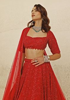 Radiate opulence with a stunning Crimson Red Bridal Lehenga Set, meticulously crafted from luxurious georgette. The red lehenga is adorned with intricate nalki and beaded embroidery in a harmonious red hue, adding depth and sophistication to the ensemble. Teamed with a Florentine neckline blouse featuring delicate bead detailing at the waistline, this set exudes elegance and refinement. Completing the look is a net fabric dupatta, embellished with a heavy hand-embroidered border, enhancing the overall allure. This bridal lehenga is a perfect choice for your special day. Composition : Lehenga, Blouse & Dupatta : Georgette, Net Care: Dry Clean Only and Vacuum Storage This product can be customized for sleeves, length and colour Delivery : 8-10 weeks as the product is hand crafted. Check Size Florentine Neckline, Studio Iris, Red Bridal Lehenga, Bridal Lehenga Red, Vacuum Storage, Red Lehenga, Indian Wedding Wear, Lehenga Blouse, Embroidered Border