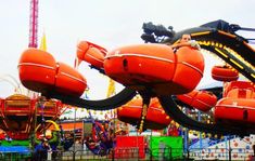 an amusement park ride with orange life vests on it's sides and people in the background