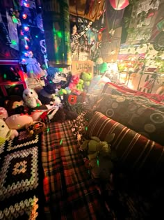 many stuffed animals are on the floor in a room with christmas lights and other decorations