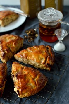 some food is sitting on a cooling rack with tea and honey in front of it