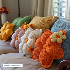 colorful knitted flower pillows lined up on a couch