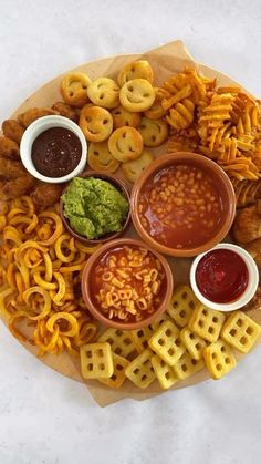 a platter filled with different types of snacks and dipping sauces on top of it