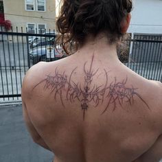 the back of a woman's neck with tattoos on it