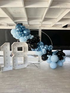 the balloon arch is decorated with black, blue and white balloons that spell out blvd