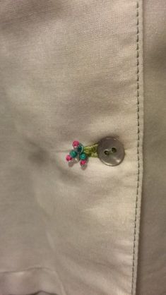 a white shirt with flowers on it and a button