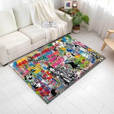 a living room with a white couch and rug covered in colorful graffiti art on the floor