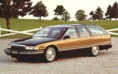 a brown and black station wagon parked in gravel