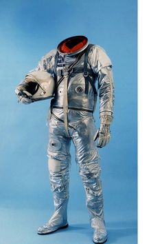 an astronaut is standing with his hands in his pockets and holding a helmet on his shoulder