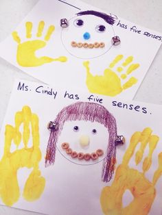 two handprints with children's drawings on them, one has a face and the other has hands