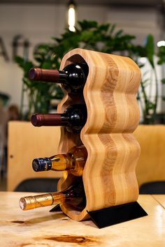 a wine rack made out of wood with several bottles in it on top of a table