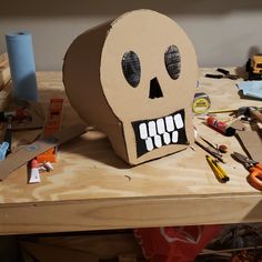 a cardboard skull sitting on top of a wooden table