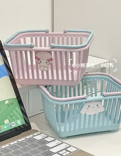 a laptop computer sitting on top of a desk next to a basket filled with toys