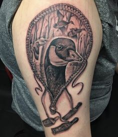 a black and white photo of a duck in a frame tattoo on the right arm