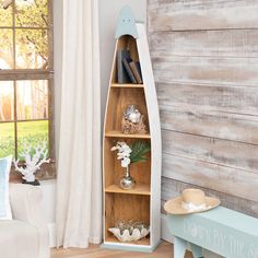 a living room filled with furniture and a wooden wall mounted book shelf next to a window