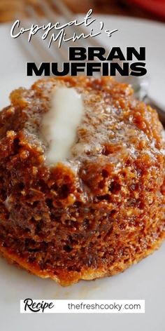 a close up of a muffin on a plate with a fork and knife in the background