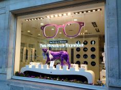 a store window with a purple cow wearing glasses