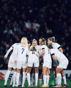 a group of women's soccer players huddle together