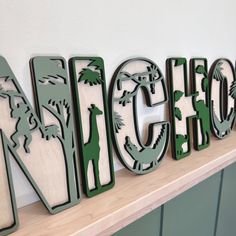 the letters are made out of metal and wood, with different animals on them that spell out each letter