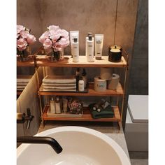 a bathroom sink and shelf with various items on it