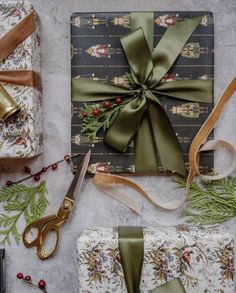 presents wrapped in wrapping paper and tied up with green ribbon, scissors and other holiday decorations