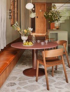 a dining room table with chairs and vases on it