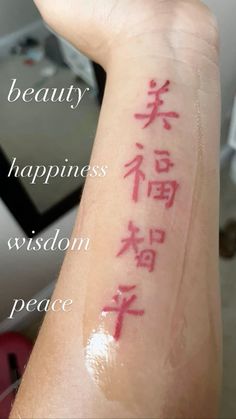 a person with chinese writing on their arm and the words beauty, happiness, vision, peace