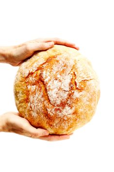 two hands holding a round bread on a white background