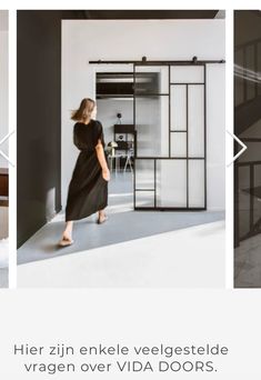 a woman in a black dress is walking through an open door and into the living room