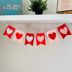 red and white paper hearts hanging from a shelf